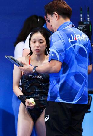 　女子高飛び込み決勝で１回目の演技を終えた荒井祭里。右は馬淵崇英コーチ（共同）