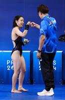 　女子高飛び込み決勝で２回目の演技を終え馬淵崇英コーチ（右）とタッチする荒井祭里（共同）
