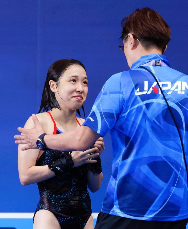 　女子高飛び込み決勝で２回目の演技を終え笑顔の荒井祭里。右は馬淵崇英コーチ（共同）