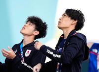 　男子複合予選、リードでルートを確認する安楽宙斗（左）と楢崎智亜（共同）