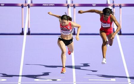 　女子１００メートル障害敗者復活戦でゴールする田中佑美（左）＝共同