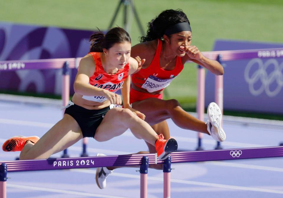 　女子１００メートル障害敗者復活戦で力走する田中佑美（左）＝共同