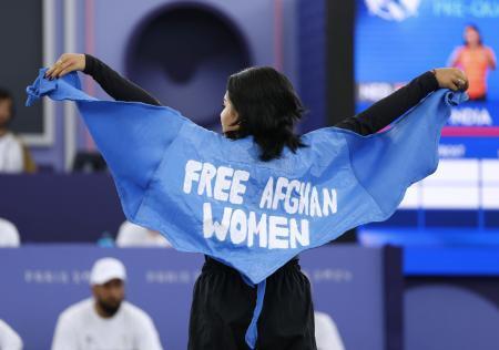 　パリ五輪のブレイキンに出場した難民選手団のマニジャ・タラシュ。英語で「アフガン女性を解放せよ」と書かれたマントを広げた。その後失格となった＝９日、パリ（共同）