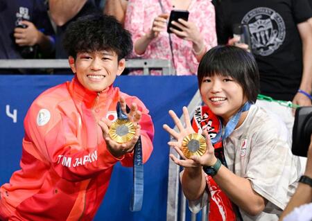 　男子フリー65キロ級で優勝し、女子57キロ級の桜井つぐみと金メダルを手にポーズをとる清岡幸大郎（共同）