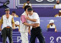 　男子１次リーグを終え、対戦相手の中国選手と健闘をたたえ合う半井重幸（右）＝共同