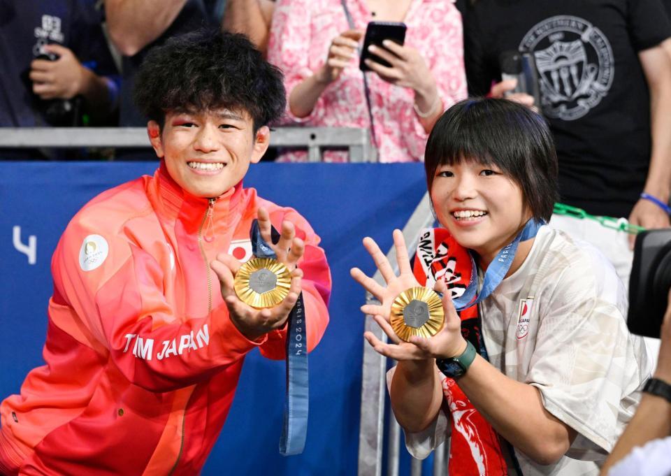 　男子フリー65キロ級で優勝し、女子57キロ級の桜井つぐみと金メダルを手にポーズをとる清岡幸大郎（共同）