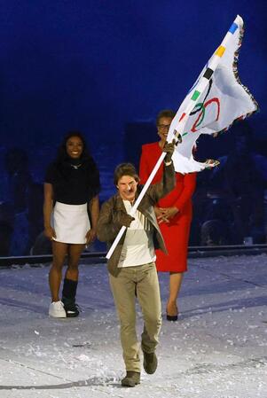 　パリ五輪の閉会式に登場し、五輪旗を掲げるトム・クルーズさん（共同）