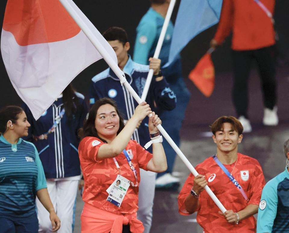 　パリ五輪の閉会式で、日の丸を手に入場する旗手の北口榛花（左）と半井重幸＝11日、パリ郊外（共同）