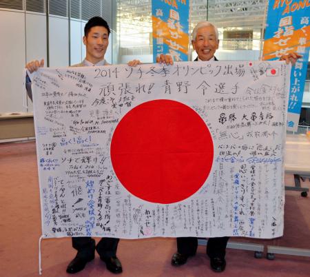 　応援メッセージが書かれた国旗を贈られた青野（左）