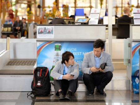 ソチ空港の発券カウンター前でひと休みするスノーボード男子ハーフパイプで銀メダルの平野歩夢（左）と銅メダルの平岡卓（共同）