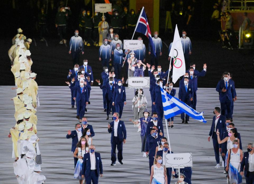 開会式で入場行進する（手前から）ギリシャ、難民選手団の選手たち＝23日夜、国立競技場