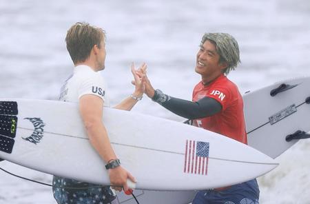 　男子準々決勝を終え、米国のコロヘ・アンディノ（左）と健闘をたたえ合う五十嵐カノア。準決勝進出を決めた＝釣ケ崎海岸サーフィンビーチ