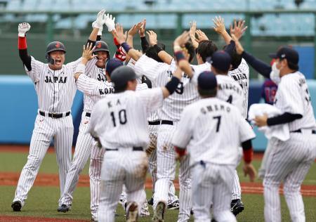 　ドミニカ共和国にサヨナラ勝ちし、（左から）生還した村上と決勝打の坂本に駆け寄る日本ナイン＝福島県営あづま球場