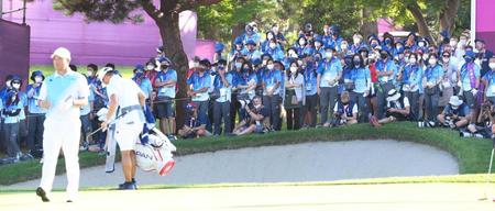 　松山英樹（手前左）を見つめる大勢のボランティアの人々