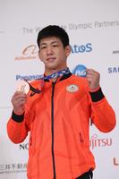 記者会見を終え、記念撮影に応じるレスリング男子グレコローマンスタイル７７キロ級銅メダルの屋比久翔平（代表撮影）