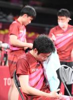 　男子卓球団体準決勝　シングルスに敗れて汗を拭う水谷隼。後方は張本智和（撮影・堀内翔）