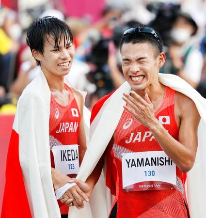 　男子２０キロ競歩で銀メダルを獲得し、銅メダルの山西利和（右）と笑顔で握手する池田向希
