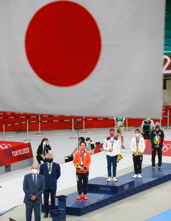　女子形の表彰式で掲揚される日の丸と銀メダルを獲得した清水希容（左手前から３人目）、金のサンドラ・サンチェス（同４人目）ら