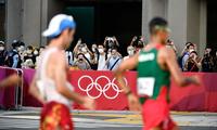 　男子２０キロ競歩に出場した選手にカメラを向ける沿道の人たち