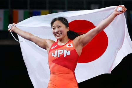 女子50キロ級で優勝し、笑顔で日の丸を掲げる須崎優衣＝幕張メッセ