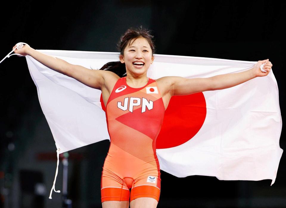 　女子５０キロ級で優勝し、笑顔で日の丸を掲げる須崎優衣