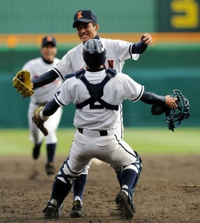 ２０１０年のセンバツで優勝を決め、山川捕手（手前）と抱き合う興南・島袋投手