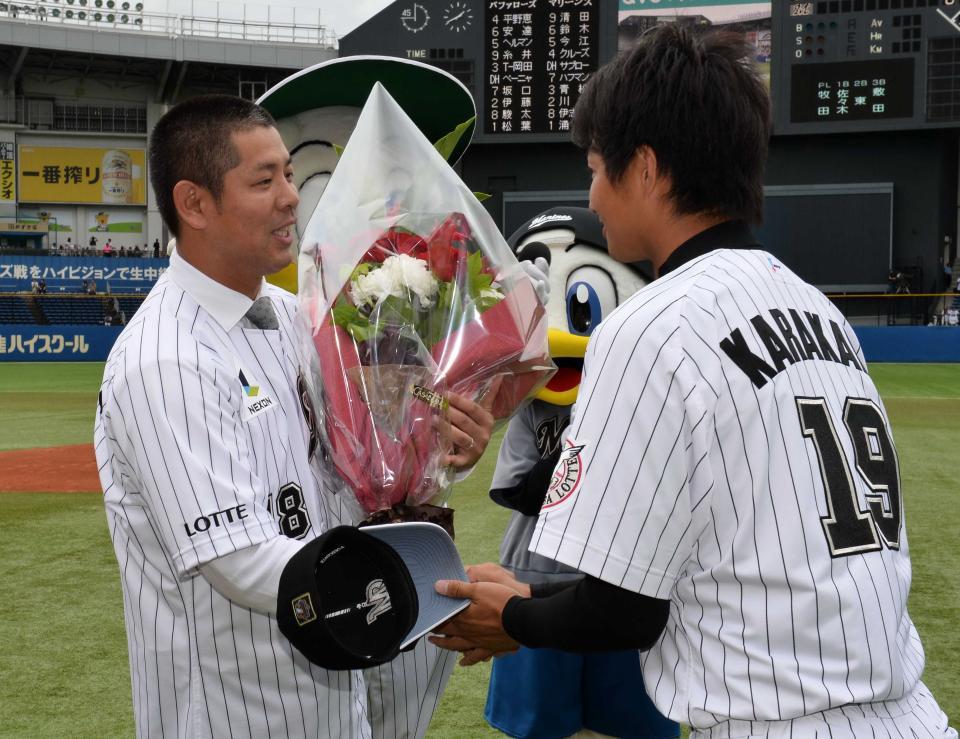 引退セレモニーでロッテ・唐川（右）から花束を受け取る清水直行氏（２０１４年６月撮影）