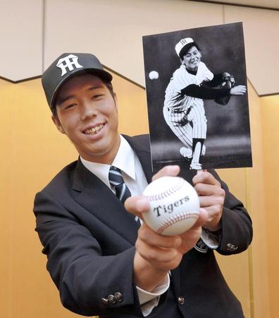 仮契約で、目標とする小林繁氏の写真を手にする阪神ドラフト５位の帝京大・青柳