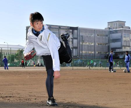 母校の校舎を背にキャッチボールする岩崎（１月２日撮影）