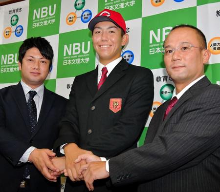 田村恵スカウト（右）、末永真史スカウト（左）と笑顔で握手する広島３位指名の日本文理大のケムナ・ブラッド・誠＝大分市の日本文理大学