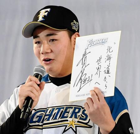 「北海道から世界へ」と色紙に書き、ファンにあいさつをする清宮