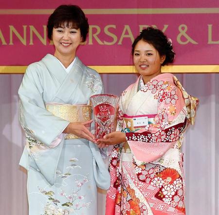 今季の賞金女王を獲得し、小林浩美会長（左）からトロフィーを受け取る鈴木愛＝１２月１８日