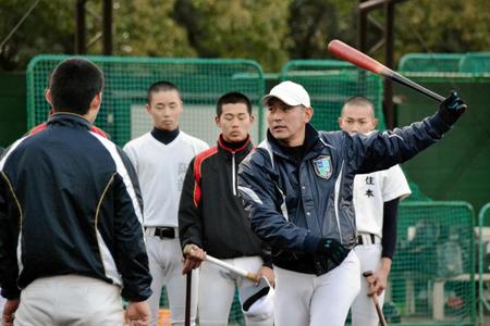 選手にスイングの指導をする神戸学院大付・岩上監督（右から２人目）