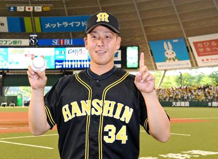 プロ初勝利を挙げ、ウィニングボールを手に笑顔を見せる谷川昌希