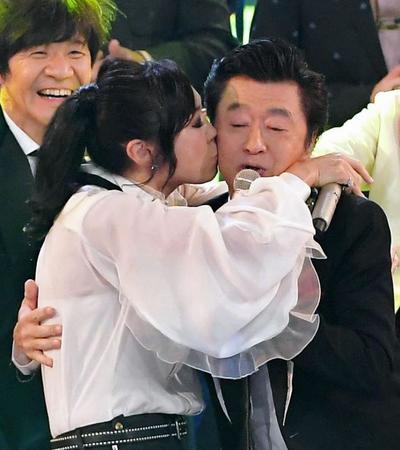 　紅白歌合戦で松任谷由実（左）にキスをされながら熱唱する桑田佳祐＝１２月３１日