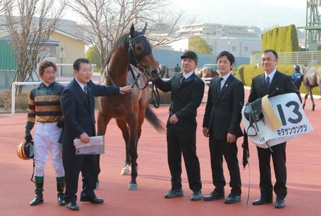 　定年前最後のレースを終えた橋口弘次郎元調教師（左から２人目）と、橋口慎介調教師（右から２人目）＝16年２月28日、阪神競馬場