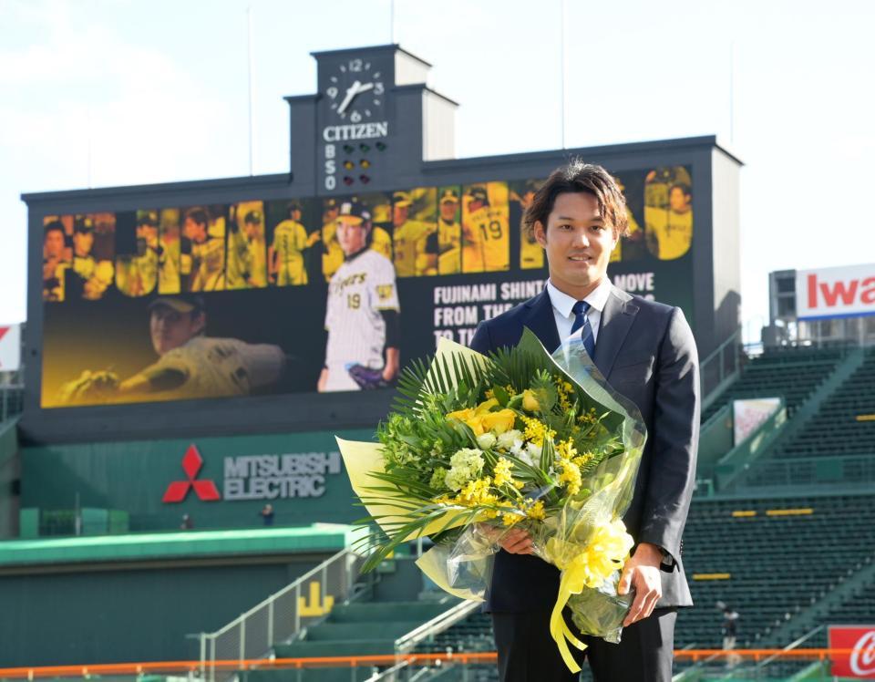 メジャー移籍会見後、花束を手に笑顔を見せる藤浪（撮影・立川洋一郎）