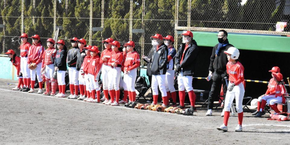 子どもたちと試合を見守る浅井さん（右から４人目）と桑原監督（同５人目）