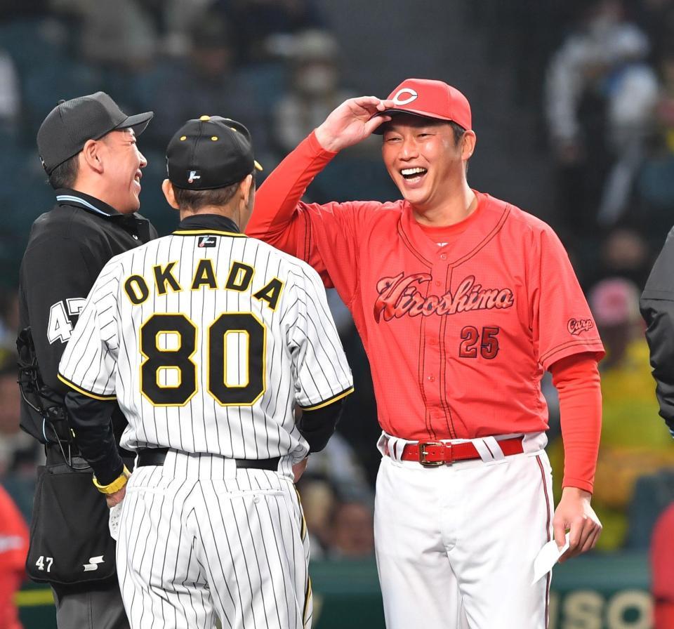 阪神・岡田彰布監督とのメンバー表交換で笑顔の広島・新井貴浩監督（右）＝甲子園