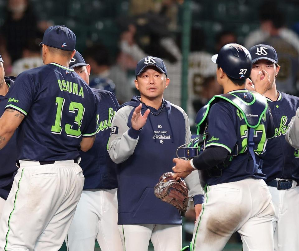 　石川（中央）は入団から２２年連続勝利を飾り捕手・中村（右）とタッチする＝１０日