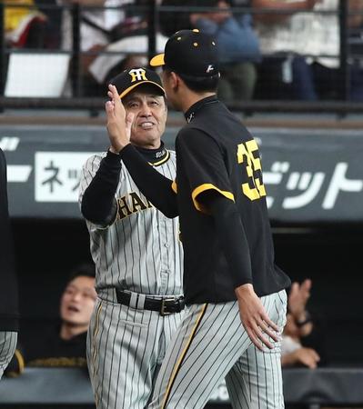 　勝利をあげ、才木（右）を迎える岡田監督＝１１日