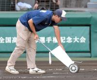 聖光学院対仙台育英のクーリングタイム中に打席のラインを引く阪神園芸・西上尚希さん＝甲子園（撮影・伊藤笙子）