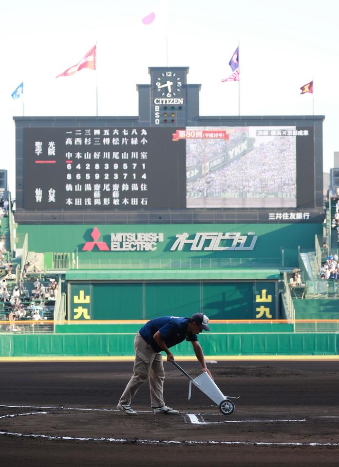 グランド整備をする阪神園芸の西上尚希さん＝甲子園（撮影・石湯恒介）