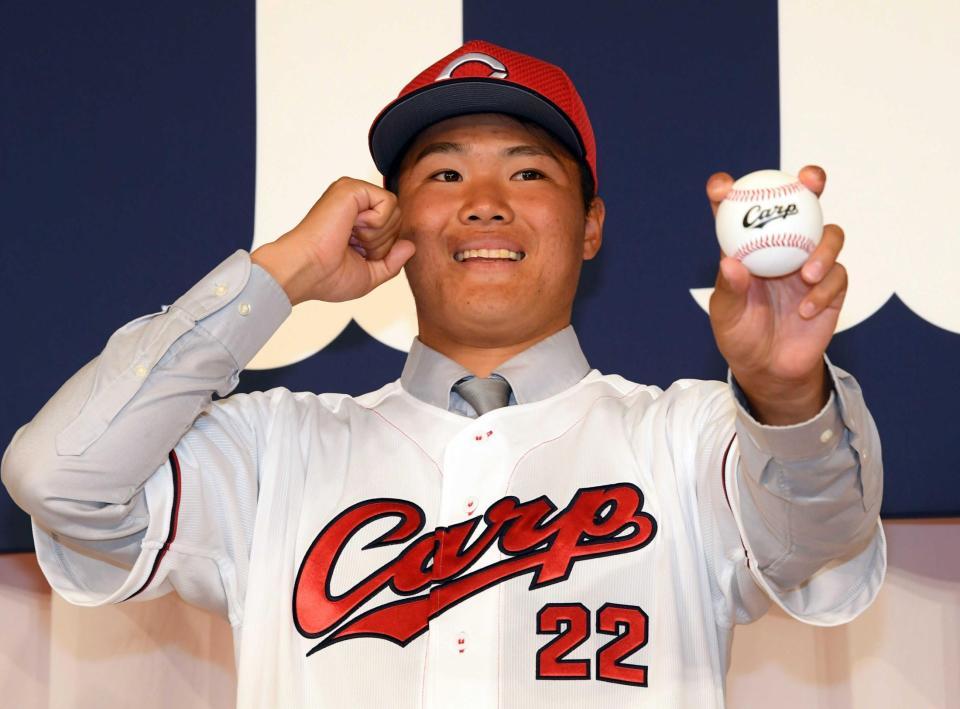 　入団会見でボールを手に笑顔を見せる高＝２０２３年１２月