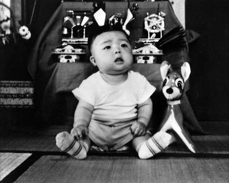 　かぶとを背に写真に納まる赤ちゃんの時の岡田氏
