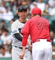 　メンバー表を交換し、新井監督と握手を交わす藤川監督＝１８日
