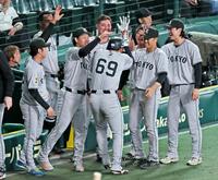 １１回、門脇の適時三塁打で勝ち越しの生還をし、ナインから手荒い祝福を受ける笹原（６９）＝撮影・立川洋一郎