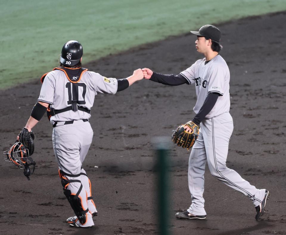 　６回を投げ終え甲斐（左）とタッチを交わす山崎伊（撮影・立川洋一郎）