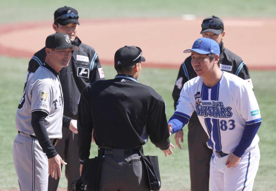 　試合前のメンバー交換で、球審と握手する桑原２軍督（右）。左は巨人・桑田２軍監督