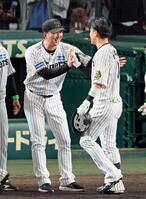 　オリックスに勝利しサヨナラ打を放った木浪（右）を迎える藤川監督＝７日